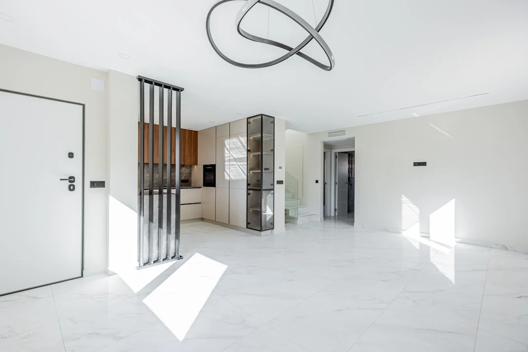 A couple is happily settling into a new home, with boxes around them and simple decor nearby.